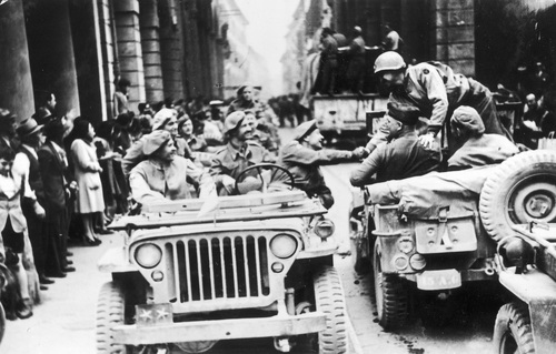 Wkroczenie polskich oddziałów 2 Korpusu Polskiego do Bolonii, 21 kwietnia 1945 r. Gen. Klemens Rudnicki (za kierownicą) podaje rękę gen. Markowi Clarkowi. Na przednim siedzeniu siedzi gen. Zygmunt Szyszko-Bohusz. (fot. z zasobu NAC)