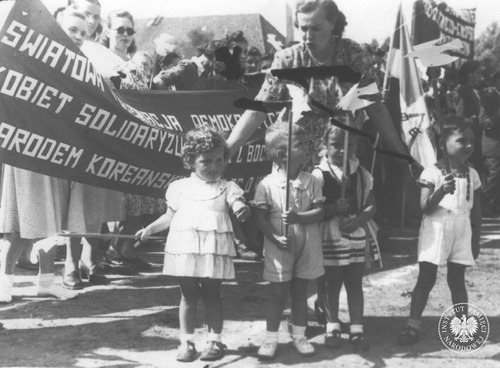 Członkinie Ligi Kobiet trzymające transparent o solidarności z narodem koreańskim podczas obchodów Narodowego Święta Odrodzenia Polski na terenie jednostki wojskowej w Dziwnowie, 22 lipca 1950 roku