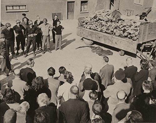 Niemieccy cywile zmuszeni przez żołnierzy amerykańskich oglądają ciała ofiar w wyzwolonym KL Buchenwald, 16 kwietnia 1945 r. (fot. www.ushmm.org)