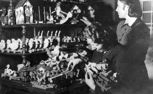 Warsztat Rady Głównej Opiekuńczej. Dwie kobiety układają zabawki na półkach, lipiec 1943 r. (fot. z zasobu NAC)