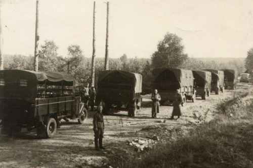 Kolumna ciężarówek z transportem więźniów Pawiaka na miejsce straceń w Palmirach, obok samochodów widoczni niemieccy żandarmi, 1939–1941 (fot. z zasobu AIPN)