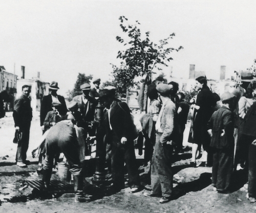 Grupa polskich cywilów przy studni na Rynku w Pińczowie; w głębi spalone zabudowania wokół Rynku, 10 IX 1939 r. (fot. IPN)