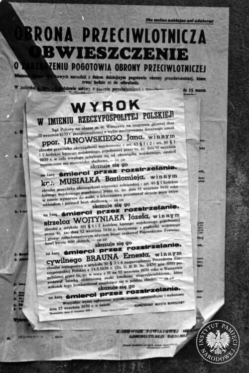 Plakaty informacyjne rozlepione na filarze Teatru Wielkiego na placu Teatralnym w Warszawie. Na pierwszym planie informacja o wyrokach śmierci na dezerterach i dywersancie, wykonanych 13 września 1939 r. Skan fotografii z Kolekcji Juliena Bryana przechowywanej w USHMM w Waszyngtonie (fot. z zasobu AIPN)