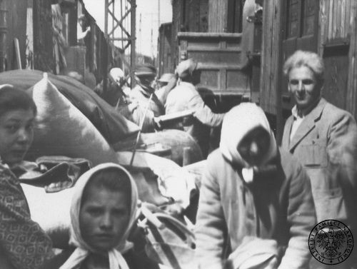 Przesiedleńcy ze wschodnich ziem II RP na jednej ze stacji kolejowych. Fotografia z albumu Państwowego Urzędu Repatriacyjnego, 1945-1946 r. (fot. z zasobu AIPN)
