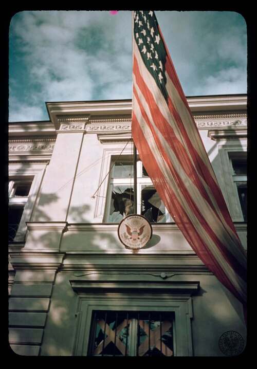 Flaga amerykańska i tabliczka z godłem na frontonie ambasady Stanów Zjednoczonych w Warszawie, mieszczącej się w willi Stanisława Lilpopa (Al. Ujazdowskie 29). Warszawa, wrzesień 1939 r. Autor: Julien Bryan. Zdjęcie z kolekcji Juliena Bryana (fot. z zasobu AIPN)
