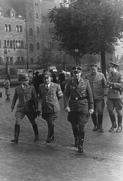 Robert Ley (w środku) i Arthur Greiser (pierwszy z prawej) w towarzystwie innych oficerów w drodze do gmachu administracji cywilnej w Poznaniu - październik 1939 r. (NAC)