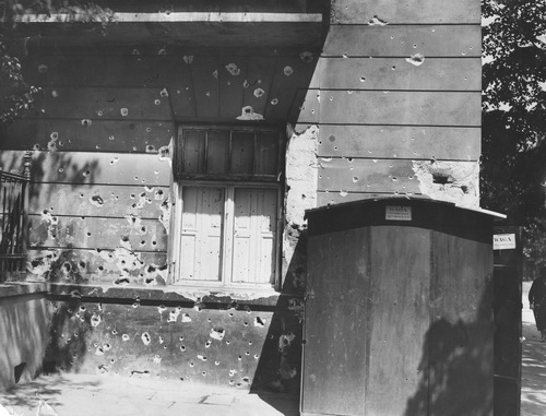 Uszkodzona ściana kamienicy przy Alejach Ujazdowskich 9. Widoczne ślady po ostrzale z karabinu maszynowego, maj 1926 (NAC)